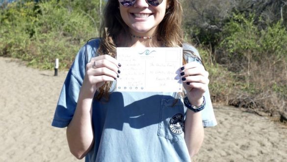 Girl holding postcard to deliver at Post Office Bay