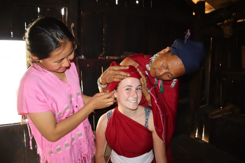 Kayah women dress tourist in lacquer leg rings and traditional attire