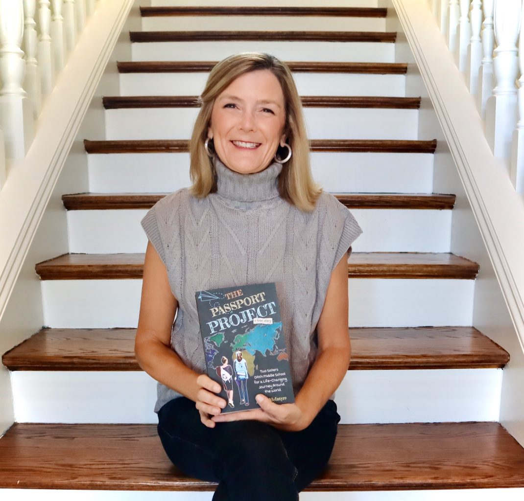 Kellie McIntyre holding copy of The Passport Project