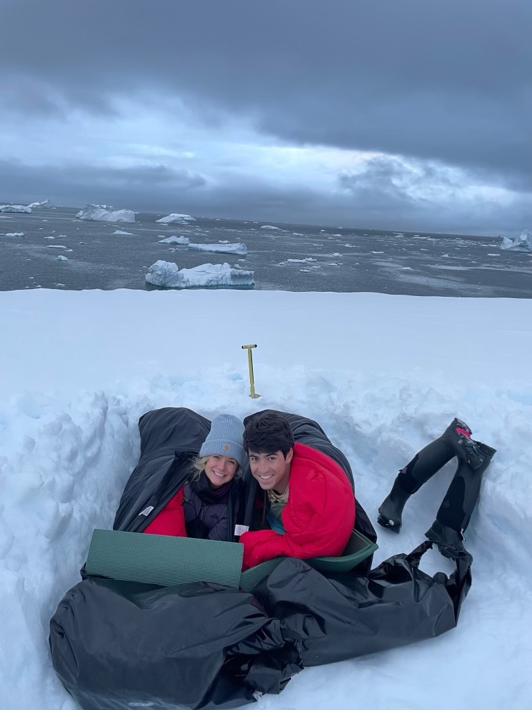 Camping in Antarctica. Couple in sleeping bags in snow.